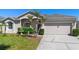 Charming home with a well-manicured front yard, featuring a two-car garage and tasteful landscaping at 213 Strathmore Cir, Kissimmee, FL 34744