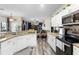 Kitchen featuring granite countertops, white cabinets, and stainless steel appliances at 213 Strathmore Cir, Kissimmee, FL 34744