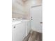 Well-lit laundry room with modern washer and dryer, shelving, and exterior door at 213 Strathmore Cir, Kissimmee, FL 34744