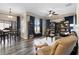Open-concept living room featuring a ceiling fan, a gray sofa, and dark wood-look floors at 213 Strathmore Cir, Kissimmee, FL 34744