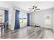 This living room features a large window with backyard views, a ceiling fan, and wood-look flooring at 213 Strathmore Cir, Kissimmee, FL 34744