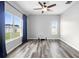 Spacious living room features a large window with backyard views, a ceiling fan, and wood-look flooring at 213 Strathmore Cir, Kissimmee, FL 34744