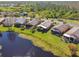Aerial perspective of homes with green lawns and community landscaping, bordering a peaceful pond at 238 Acadia Dr, Poinciana, FL 34759