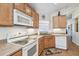 Efficient kitchen with wooden cabinets and white appliances at 238 Acadia Dr, Poinciana, FL 34759