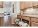Kitchen features pull-out shelving with dishware and decor, as well as neutral countertops and a view into the living room at 238 Acadia Dr, Poinciana, FL 34759