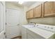 Laundry room with washer and dryer and oak cabinets at 238 Acadia Dr, Poinciana, FL 34759