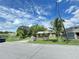 Exterior shot of a cute home framed by palm trees, with a gated front yard at 2406 Thelma Ave, Haines City, FL 33844