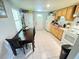 Cozy kitchen featuring wood cabinets, white appliances, and a dining table at 2406 Thelma Ave, Haines City, FL 33844