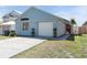 A well-maintained single-story home featuring a concrete driveway and small bushes at 2432 Olive Branch Way, Orlando, FL 32817
