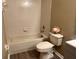 Bathroom featuring a tub, ceramic tiles, and toilet with light grey wood-look flooring at 2520 Azzurra Ln, Ocoee, FL 34761