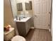 Bathroom featuring a gray vanity with framed mirror and toilet with grey wood-look flooring at 2520 Azzurra Ln, Ocoee, FL 34761
