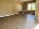 Spacious living room featuring wood-look flooring, neutral paint, and a bright window overlooking the landscape at 2520 Azzurra Ln, Ocoee, FL 34761