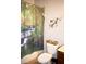 Cozy bathroom featuring a decorative nature-themed shower curtain and a decorative leaf on the wall at 2787 Oakwater Dr # 149, Kissimmee, FL 34747