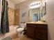 Well-lit bathroom featuring a single vanity, decorative mirror, and tiled shower at 2787 Oakwater Dr # 149, Kissimmee, FL 34747