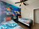 Beautiful themed bedroom featuring twin beds, a ceiling fan, and a unique ocean mural at 2787 Oakwater Dr # 149, Kissimmee, FL 34747