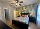 Bedroom with bed, fan, wallpaper, lamps, and access to bathroom at 2787 Oakwater Dr # 149, Kissimmee, FL 34747