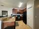 The kitchen features wood cabinets, black appliances, neutral countertops and tiled floor at 2787 Oakwater Dr # 149, Kissimmee, FL 34747
