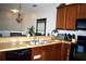 The kitchen showcases wood cabinetry, stainless steel sink, black appliances, and bar seating at 2787 Oakwater Dr # 149, Kissimmee, FL 34747
