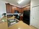Modern kitchen with wooden cabinetry, black appliances, and neutral countertops is equipped with everything you need at 2787 Oakwater Dr # 149, Kissimmee, FL 34747