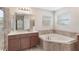 Bright primary bathroom with soaking tub, tile surround and double windows at 30439 Gidran Ter, Mount Dora, FL 32757