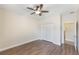 Neutral bedroom featuring hardwood floors, ceiling fan, and a double door closet at 30439 Gidran Ter, Mount Dora, FL 32757