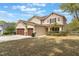 Two-story home featuring a three-car garage, manicured landscaping, and neutral stucco exterior at 30439 Gidran Ter, Mount Dora, FL 32757