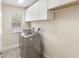 Laundry room with gray front load washer and dryer and white cabinets at 30439 Gidran Ter, Mount Dora, FL 32757