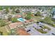 This aerial view shows residences with common area and pool; a neighborhood with mature trees and a pond are in the distance at 31 Las Palmas Way, Kissimmee, FL 34743