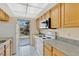 Well-lit kitchen featuring wood cabinets, modern appliances, and a sliding door to the backyard at 31 Las Palmas Way, Kissimmee, FL 34743