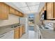 Functional kitchen offering wood cabinetry, white appliances, and backyard access at 31 Las Palmas Way, Kissimmee, FL 34743