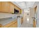 Efficient kitchen design with wood cabinets, stainless microwave, and backyard views from the stove at 31 Las Palmas Way, Kissimmee, FL 34743
