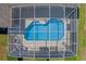 Birds eye view of a screened in pool with lounge chairs and a small table with chairs set on the patio at 310 N Hampton Dr, Davenport, FL 33897