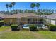 A backyard view featuring a screened-in pool, green lawn, and mature hedges for privacy and serenity at 310 N Hampton Dr, Davenport, FL 33897