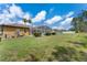 Spacious backyard with a screened pool area, lush green grass and mature landscaping at 310 N Hampton Dr, Davenport, FL 33897