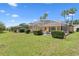 Beautiful backyard view with a screened pool area, lush green grass and mature shrubs at 310 N Hampton Dr, Davenport, FL 33897
