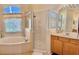 Bathroom features include a large tub under a window, a glass shower, and a vanity at 310 N Hampton Dr, Davenport, FL 33897
