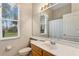 Cozy bathroom with large mirror, toilet and sink under the window for natural lighting at 310 N Hampton Dr, Davenport, FL 33897