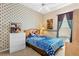 Whimsical bedroom with patterned wallpaper, blue bedding, and soft natural light at 310 N Hampton Dr, Davenport, FL 33897