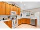 Open kitchen with wooden cabinets, modern appliances, and white countertops at 310 N Hampton Dr, Davenport, FL 33897