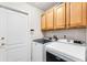 Laundry room with modern washer and dryer units and upper wooden cabinets at 310 N Hampton Dr, Davenport, FL 33897