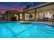 Screened pool area at dusk with covered patio and inviting swimming pool at 310 N Hampton Dr, Davenport, FL 33897