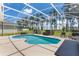 Enclosed pool and patio area with an adjacent, beautifully landscaped backyard at 310 N Hampton Dr, Davenport, FL 33897