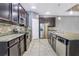 Modern kitchen with stainless steel appliances, granite countertops, and dark wood cabinets at 3131 Bass Boat Way, Kissimmee, FL 34746