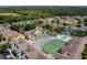 Aerial view of a colorful community with a pool, tennis courts, and surrounding trees at 3161 Britannia Blvd # A, Kissimmee, FL 34747