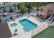 Community pool with lounge chairs, umbrellas, and a hot tub surrounded by buildings at 3161 Britannia Blvd # A, Kissimmee, FL 34747