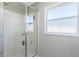 Tiled shower with a glass enclosure, built-in seat, and a frosted glass window for natural light at 3263 Lorimar Ln, St Cloud, FL 34772