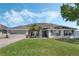 Charming one-story home featuring a well-manicured lawn and a two car garage at 3263 Lorimar Ln, St Cloud, FL 34772