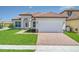 Charming single-story home featuring a red tile roof, arched entryway, and a brick-paved driveway at 362 Villa Sorrento Cir, Haines City, FL 33844