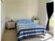 Bright bedroom with neutral walls and carpet, two side tables, and a blue striped comforter at 366 Jaybee Ave, Davenport, FL 33897