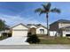 Charming single Gathering home with a two-car garage and a well-manicured lawn and a tall palm tree at 366 Jaybee Ave, Davenport, FL 33897